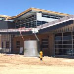 A partially constructed school building with a water cistern