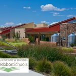 Photo of the exterior of the Amy Biehl Community School overlaid with the U.S. Department of Education's Green Ribbon School logo